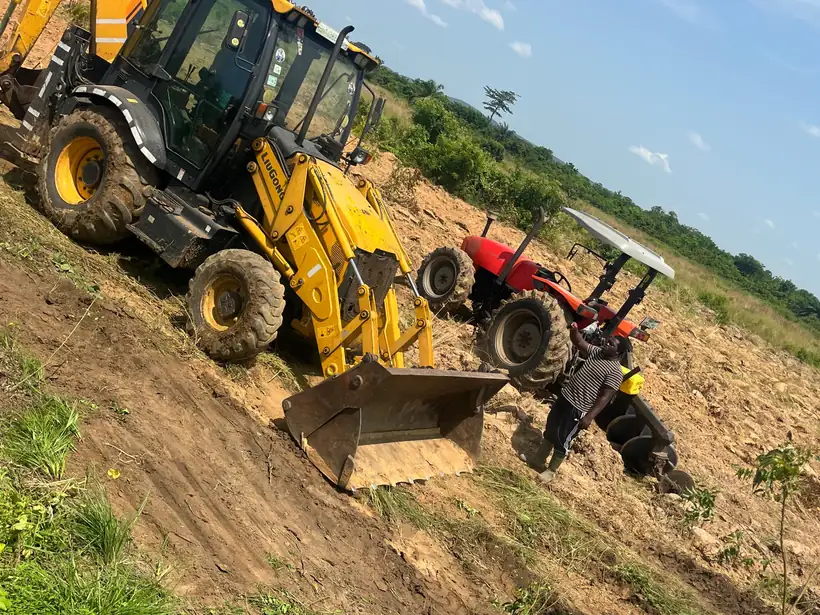 Backhoe and power tiller on site